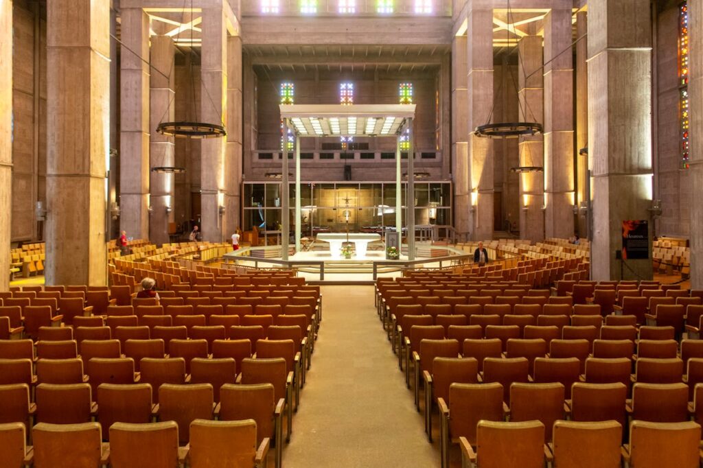 Spacious interior of a modern church in Le Havre, featuring wooden seating and unique architecture.